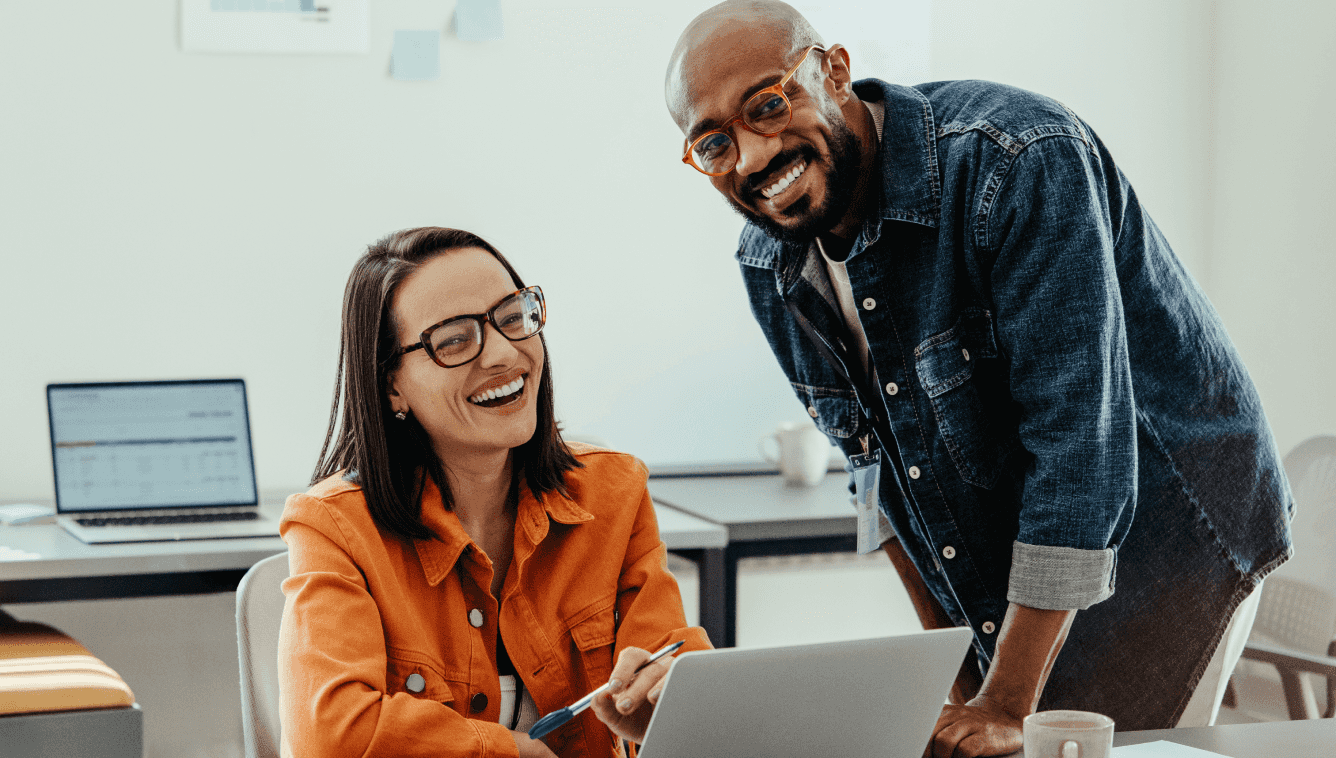 Um homem e uma mulher sorridente olhando para o computador